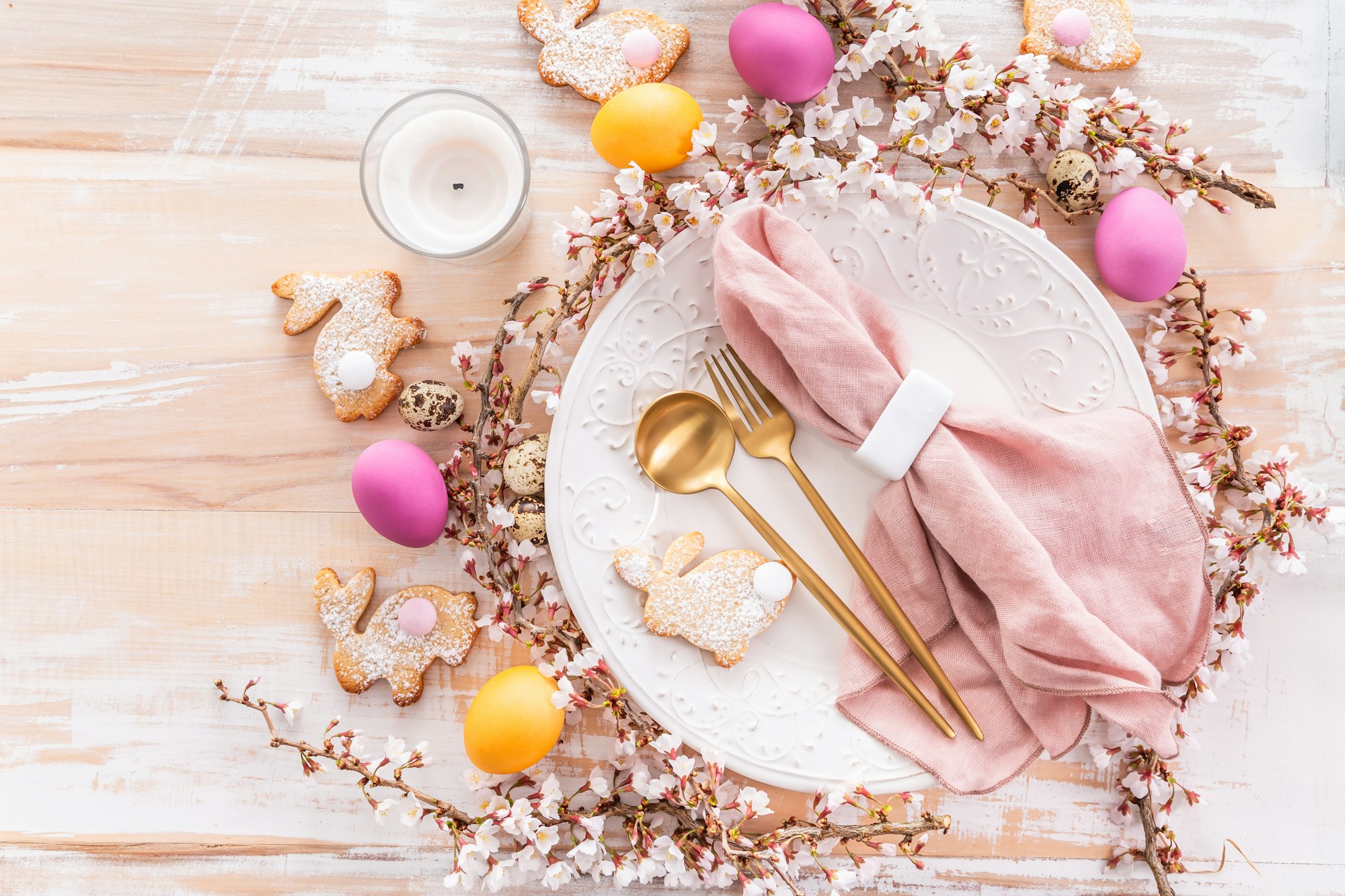 Easter table setting with colorful eggs and bunny cookies